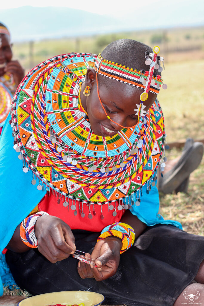 Artisan at Work on Beadwork: A skilled artisan meticulously threading beads to create a detailed, handcrafted design, reflecting the care and precision behind each piece.